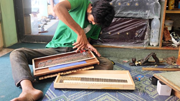 1 - A worker repairs a harmonium