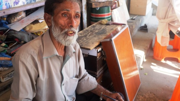 3 - Waheed answers a question while repairing harmonium